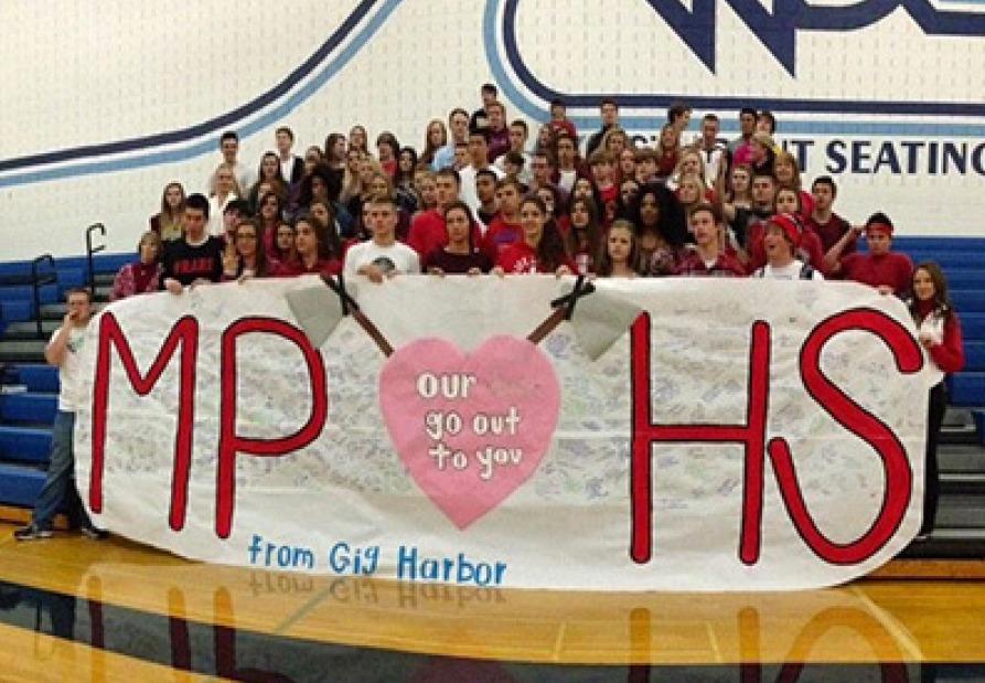 Students dressed up in red and holding a poster in support of Marysville Pilchuck HS. and