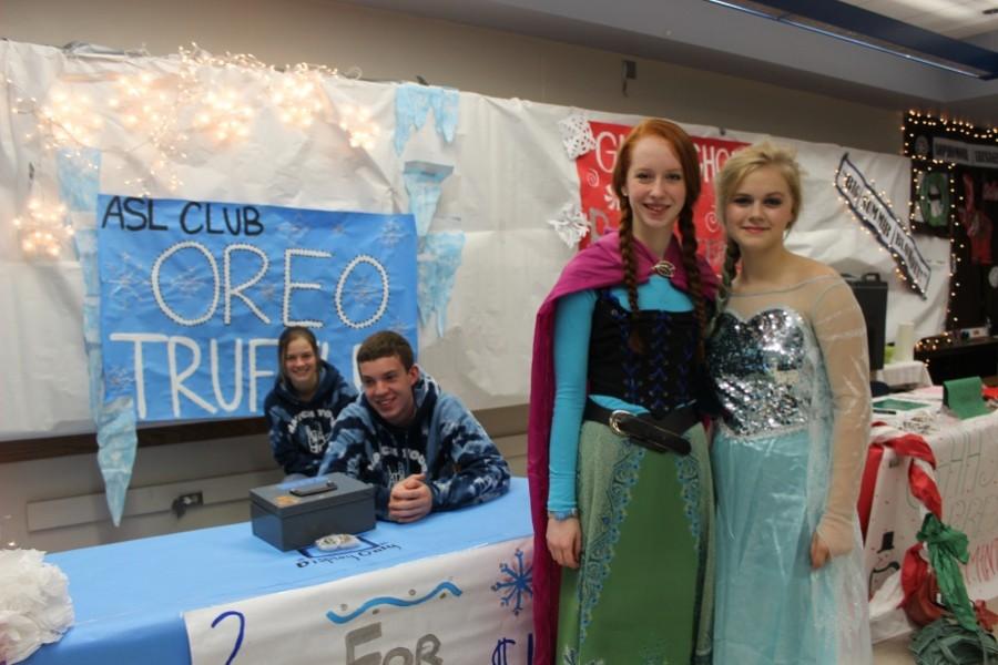 Sophomores+Fiona+Ray+and+Haley+Shide+dressed+up+as+Anna+and+Elsa+in+front+of+the+ASL+booth.