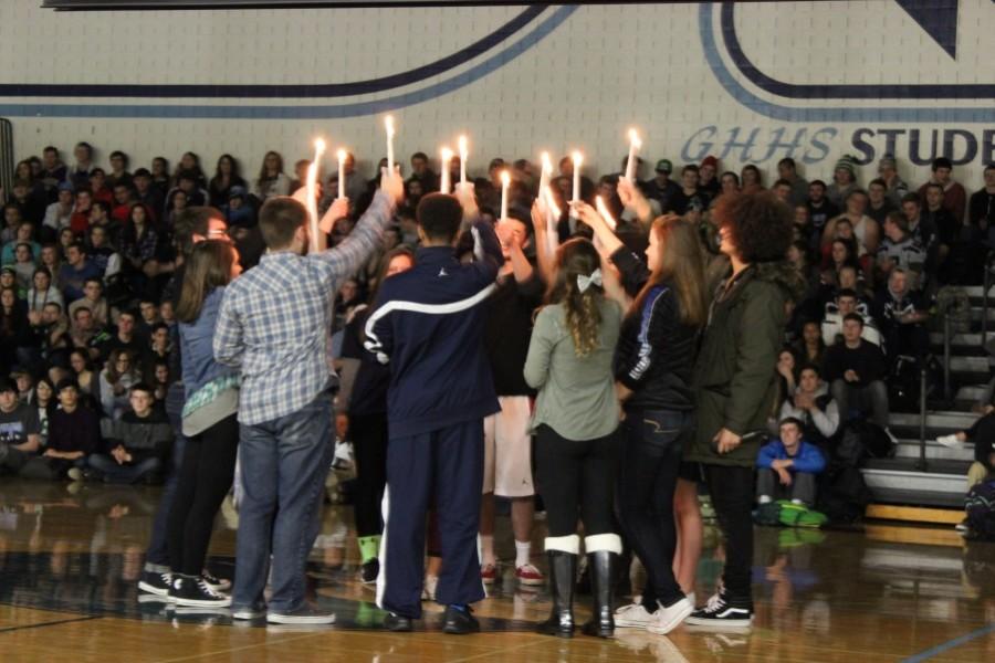 Leadership+students+come+together+with+lit+candles+at+the+MLK+assembly.