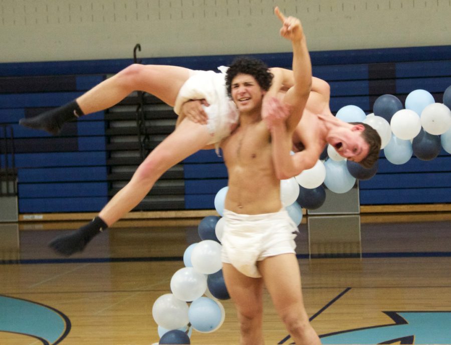 Martin Brazier lifts up his opponent, Parker Cowan after a sumo-wrestling match in adult diapers.
