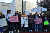 Students at Gig Harbor High School raise their homemade signs outside of the school for 17 minutes to protest against gun violence in schools. Photo by Kai Cole.