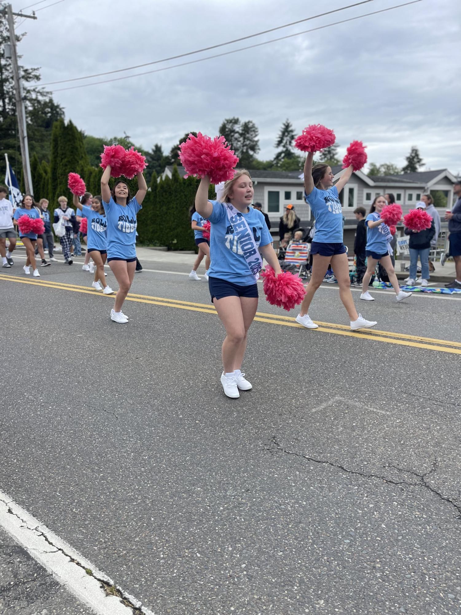 Cheerleaders wave pink pom-poms