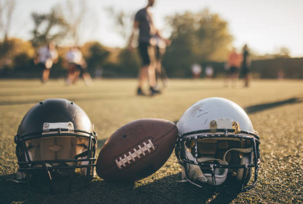 American football helmets and ball on the playing field.